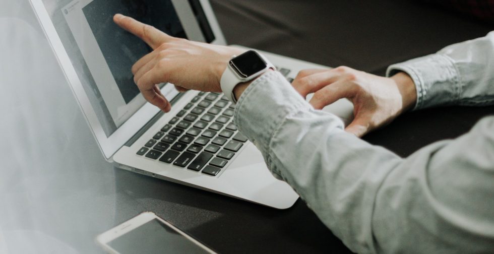 Man pointing at laptop screen